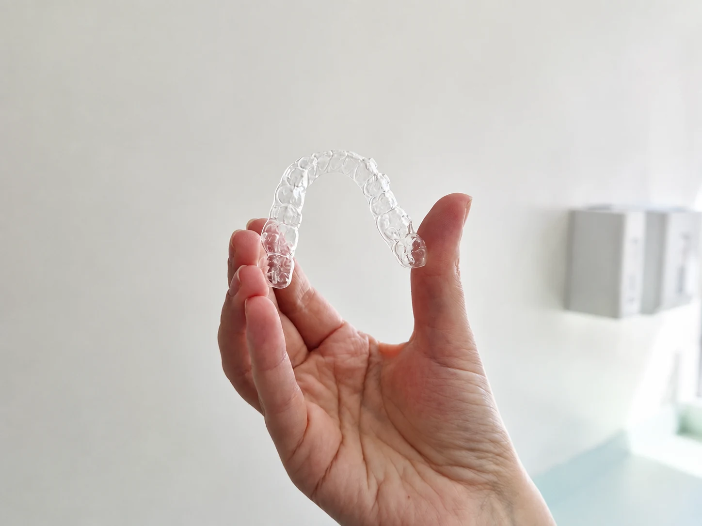 Alinhador invisível transparente sendo segurado pela mão